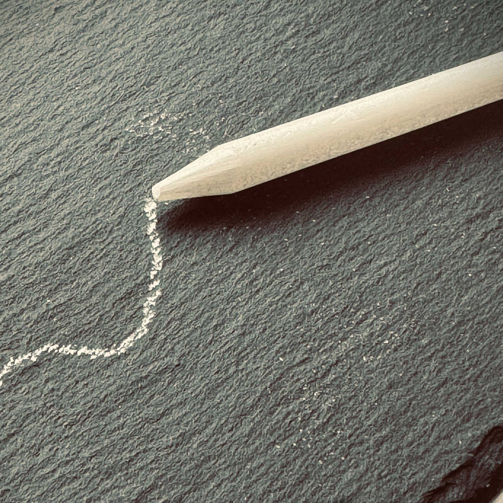 Chalk pencil on a chalkboard with a example line. 