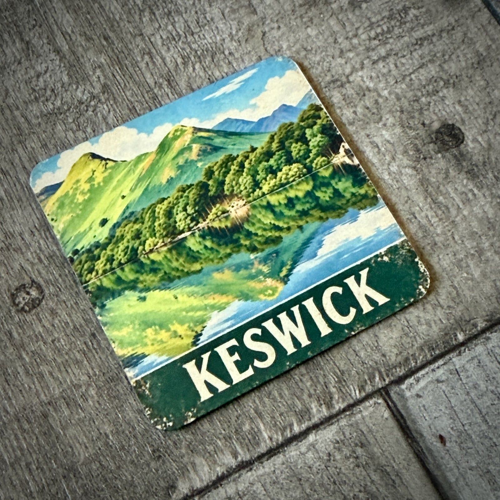 Keswick metal fridge magnet featuring vintage-style Catbells artwork, showing the attached magnet on the reverse and 60 × 60mm size.