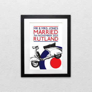 A black framed print featuring a Mod-inspired Targets and Scooters wedding design with a captivating London tube-style font. The retro-chic artwork showcases a playful and sophisticated motif, adding a touch of nostalgic charm to any wedding venue. The black frame complements the print, creating an elegant and eye-catching centerpiece for your special day